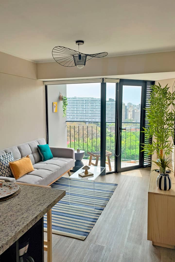 Obývacia izba s množstvom prirodzeného osvetlenia a krásnym výhľadom na symbolický park Reducto Nº2 s krásnymi zelenými plochami, ktoré je k dispozícii na bezplatnú návštevu.