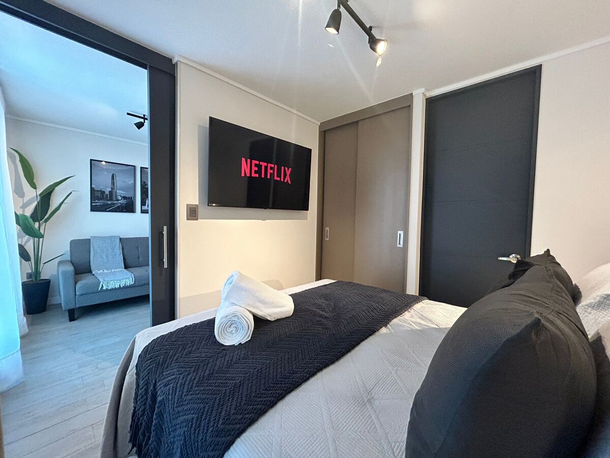 سرير مزدوج مع تلفزيون في غرفة النوم يشمل منصة Netflix