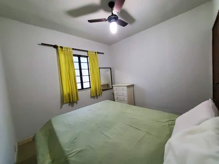 Primer dormitorio de la cabaña con una cama doble y ventilador de techo