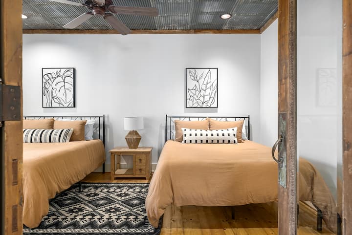 Thoughtfully designed bedroom with two cozy beds, warm neutral tones, and rustic details, perfect for kids, friends, or additional guests staying at Adobe Creek Ranch near New Braunfels.