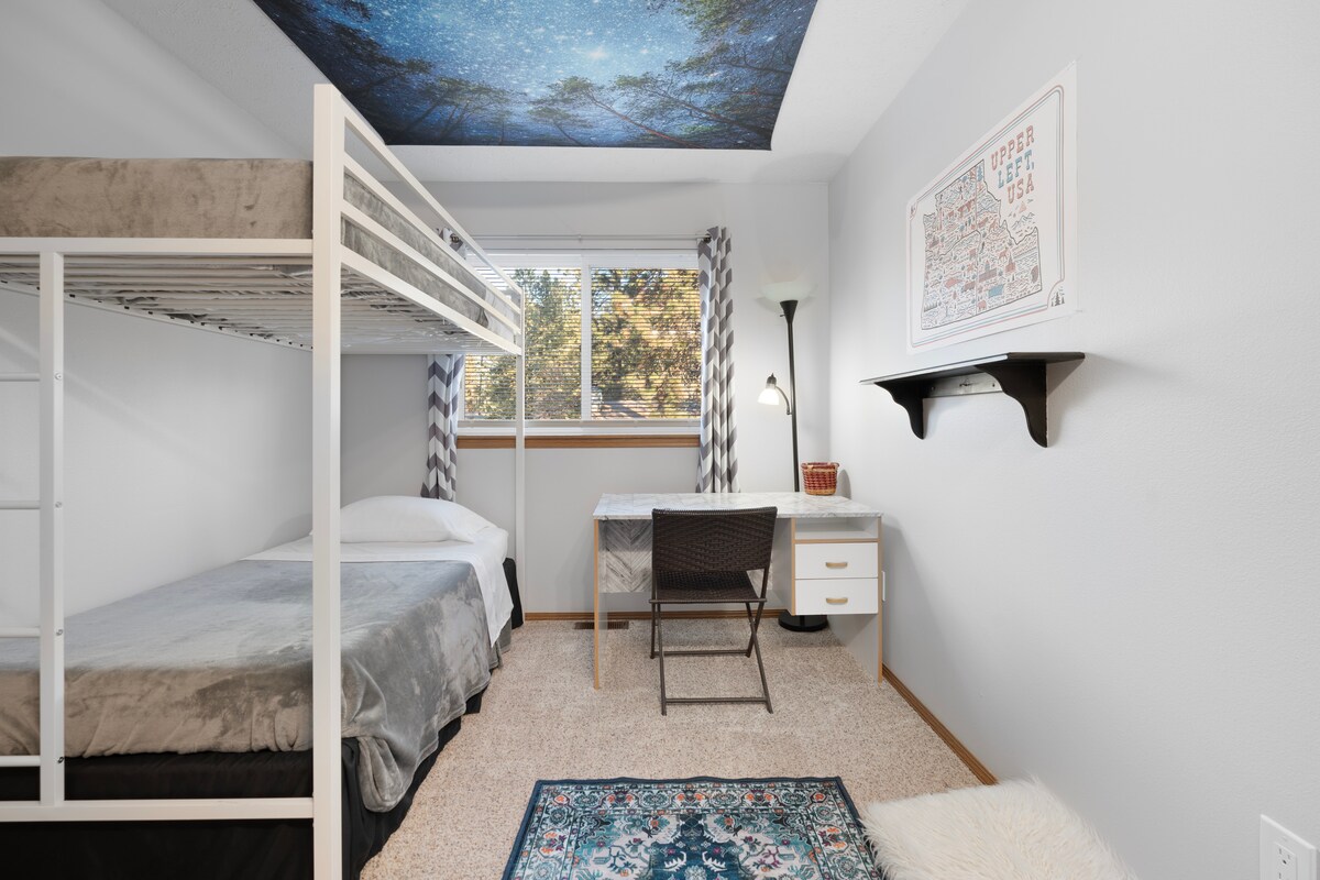 这间有趣的房间设有两张单人床（双层床风格）、遮光窗帘和百叶窗、专用工作空间，以及带衣柜和衣架的大量衣物储物柜。