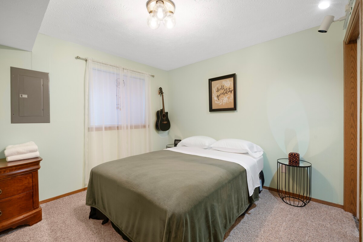 音乐家的房间配有标准双人床、百叶窗、衣物储物柜和衣柜空间，配有衣架和篮子。