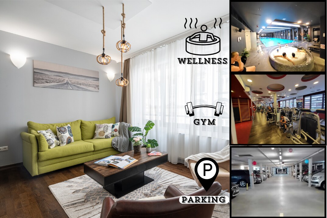 A spacious living area features a cozy green sofa and a coffee table on a warm wooden floor. Large windows allow natural light to fill the room, with light fabric curtains softly filtering the view. Icons illustrating wellness, gym, and parking amenities are displayed for guest reference.