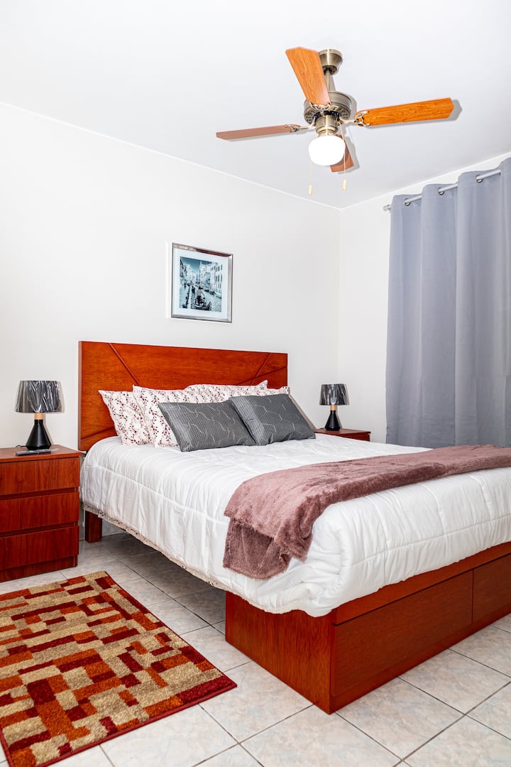 The master bedroom, 60"TV, a ceiling fan.