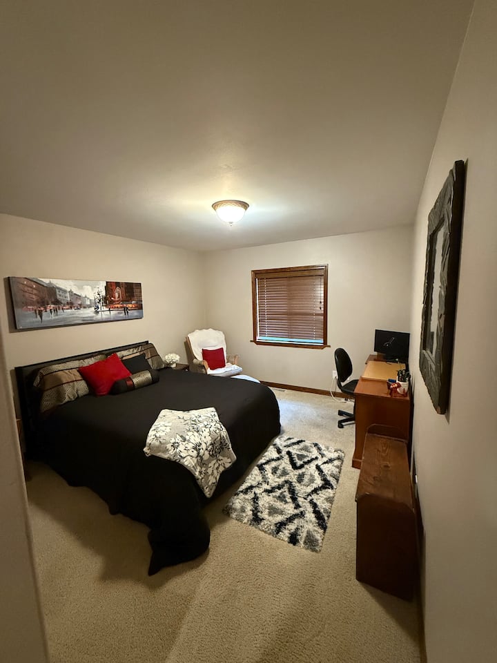 3e slaapkamer met queensize bed en bureau.