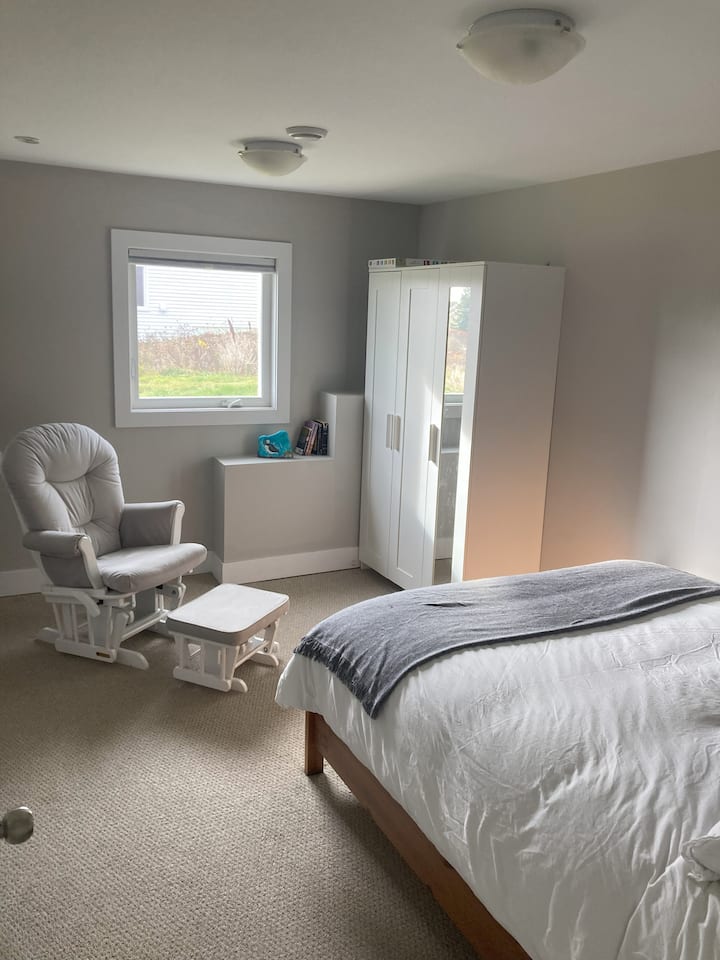 Privatna spavaća soba 9,5 stopa x 14,5 stopa s bravom. Udoban bračni krevet s poplunom, stolicom za ljuljanje i oklopom. Tu je i sjenilo za zamračivanje.