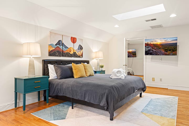 Relájate en un dormitorio bellamente diseñado con una cama tamaño king, obras de arte con temática de montaña y luz natural, creando una escapada acogedora y pintoresca.