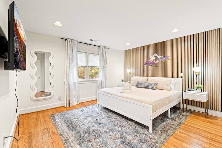 Descansa en un dormitorio elegante con detalles en paneles de madera, iluminación moderna y un ambiente sereno para una noche de sueño tranquilo.