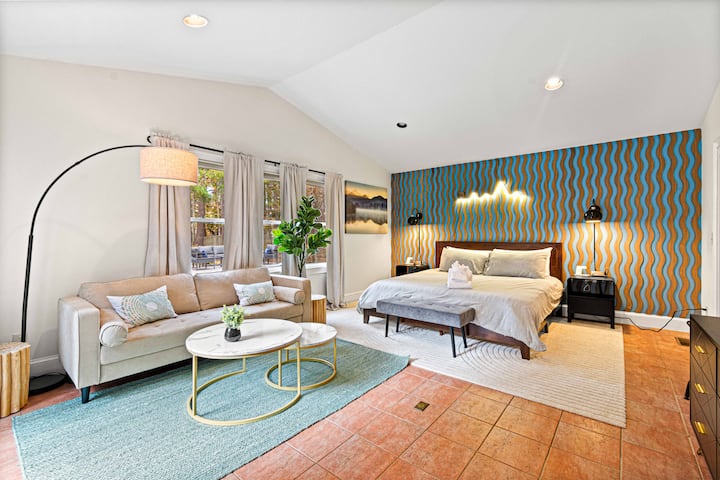 Relájate en una lujosa suite principal con una cama tamaño king, una decoración elegante y una sala de estar privada: tu escapada serena después de un día de aventura.