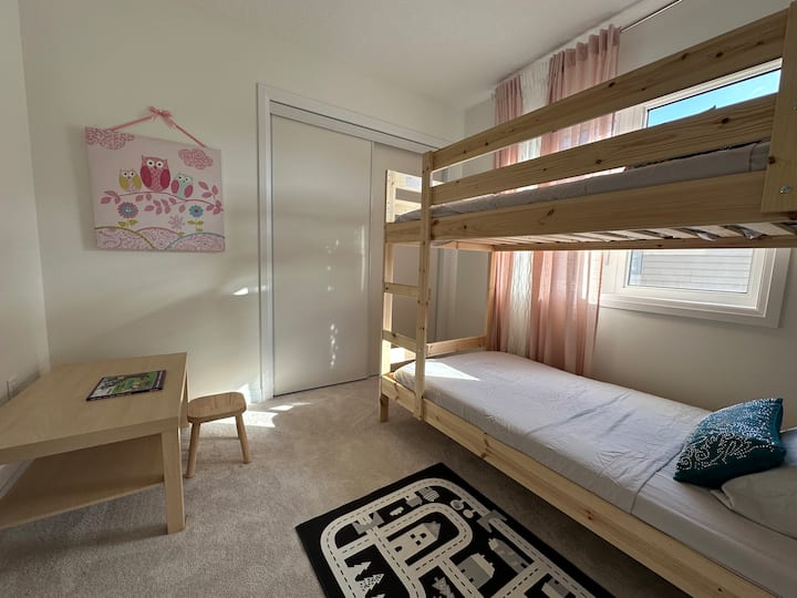 Una litera doble para tus hijos pequeños. Con ropa de cama, mesa y silla, armarios con perchas.