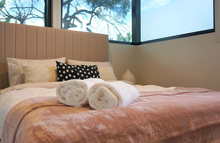 Cómoda cama tamaño queen y grandes gabinetes de armario, fácil acceso al baño.