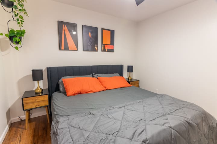 ห้องนอนที่ทันสมัยและอบอุ่นพร้อมเตียงคิงไซส์ที่สบาย งานศิลปะที่มีสไตล์ และผ้าปูที่นอนนุ่ม เหมาะสำหรับการผ่อนคลายหลังจากผจญภัยมาทั้งวัน