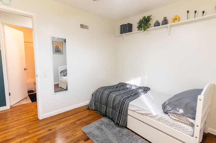 ห้องนอนสไตล์มินิมอลพร้อมเตียงคู่ขนาดคิงไซส์ที่สบาย พื้นไม้อบอุ่น และการตกแต่งที่ให้ความรู้สึกสงบ เหมาะสำหรับนักเดินทางที่มีเด็ก