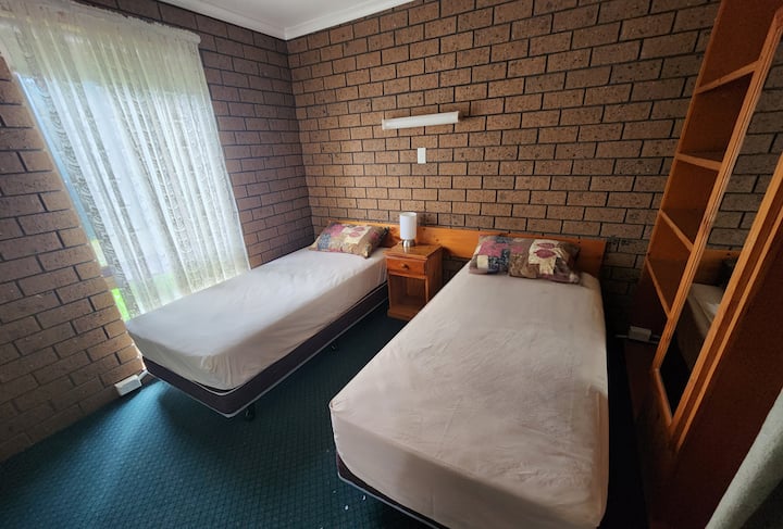 两张单人床、床上用品、枕头、床头柜、衣柜、衣架、镜子、床上荧光灯、触摸灯、遮光窗帘、地毯。