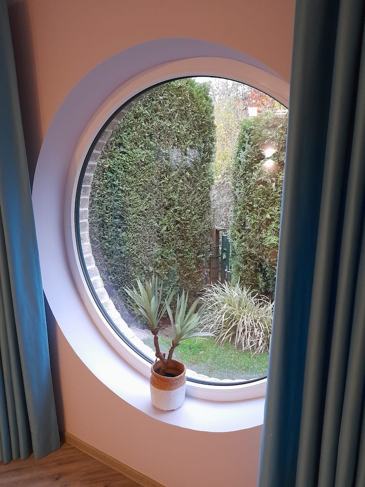 หน้าต่างห้องนอนขนาดใหญ่ทรงกลมพร้อมวิวป่า