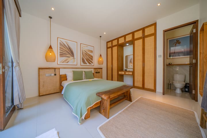 Stilvoll und gelassen – Entspanne dich in diesem durchdacht gestalteten Schlafzimmer mit einem Bett und einem beruhigenden Gartenblick, perfekt für dein luxuriöses Bali-Villa-Erlebnis.