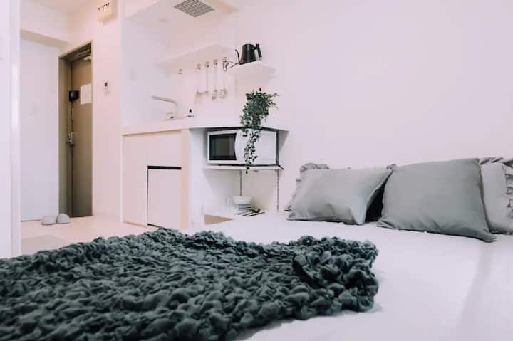 Este quarto minimalista tem uma televisão e ar condicionado para o máximo conforto. A cozinha adjacente está totalmente equipada com todos os itens essenciais, perfeitos para preparar refeições durante a sua estadia. Um espaço elegante e funcional para sua conveniência.