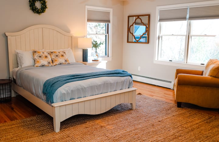 Elegante dormitorio tamaño queen con televisión y almacenamiento 