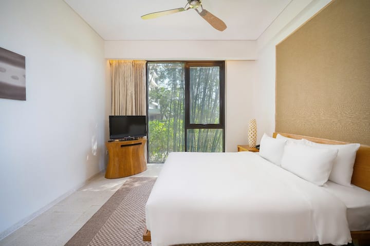 Retirez-vous dans cette chambre paisible avec un lit king size, des draps frais, des lampes de chevet et une télévision murale pour des soirées confortables.


