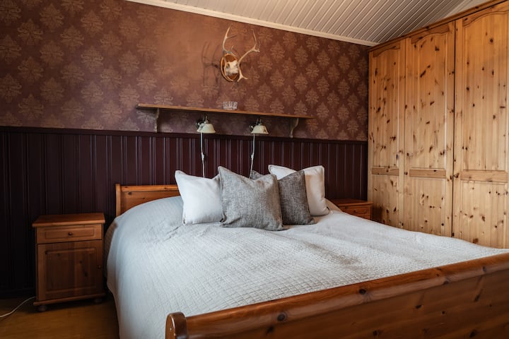 Sovrum med dubbelsäng, beläget direkt vid trappan och intill vardagsrummet.