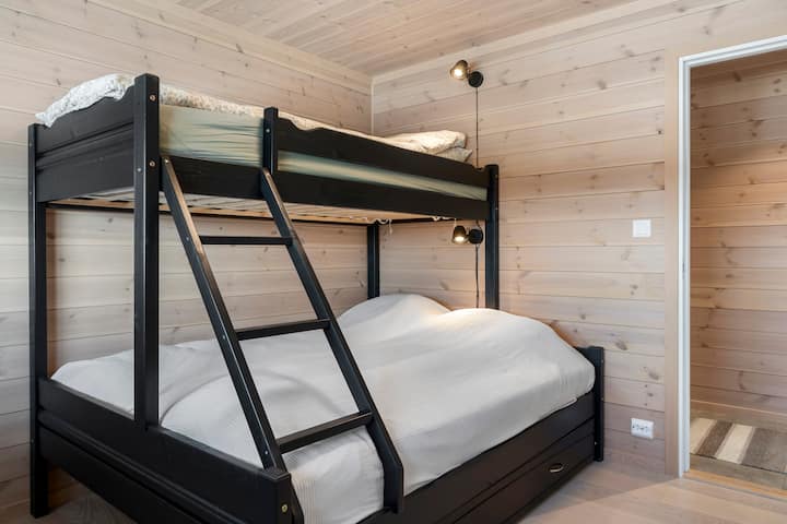 Bedroom with bunk bed with 150 cm wide bed downstairs and 90 cm bed upstairs. The room is equipped with a large dresser, mirrors, reading lamps and pegs. From the window you can enjoy an amazing view of Eggedal.