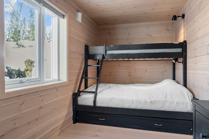 Bedroom with bunk bed with 150 cm wide bed downstairs and 90 cm bed upstairs. The room is equipped with a large dresser, mirror, reading lamps and hooks.