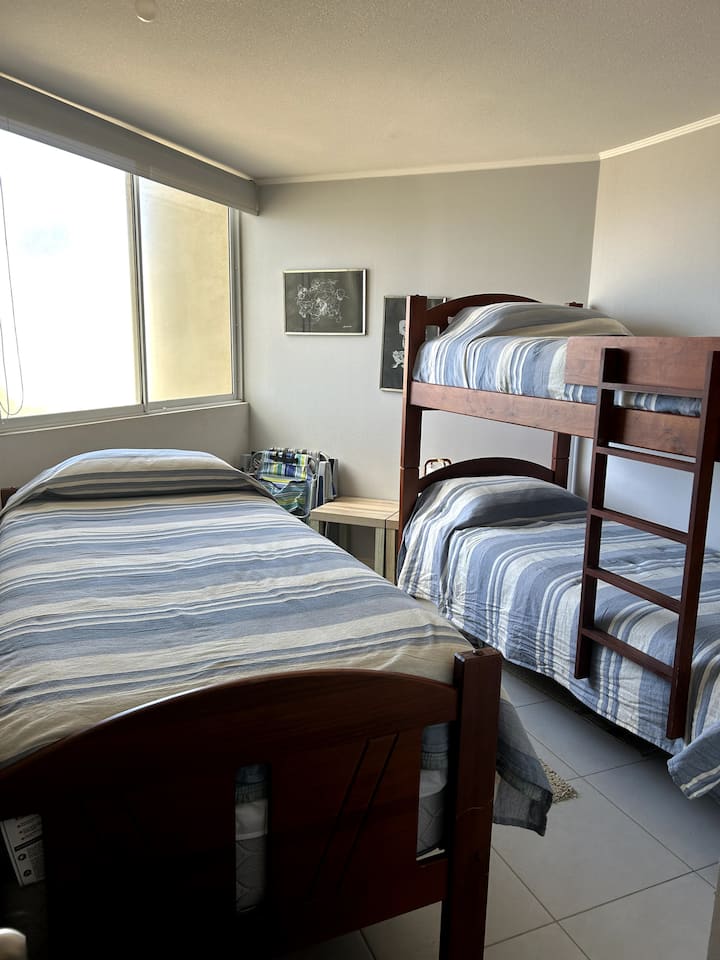 חדר שינה עם שתי מיטות קומתיים ומיטת יחיד אחת