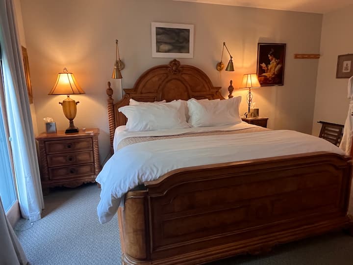 The room provides a cozy and inviting atmosphere, ideal for relaxing after a full day of mountain adventures. It is equipped with a king-sized bed, dressed in a plush duvet and numerous pillows for a rejuvenating night's rest. 