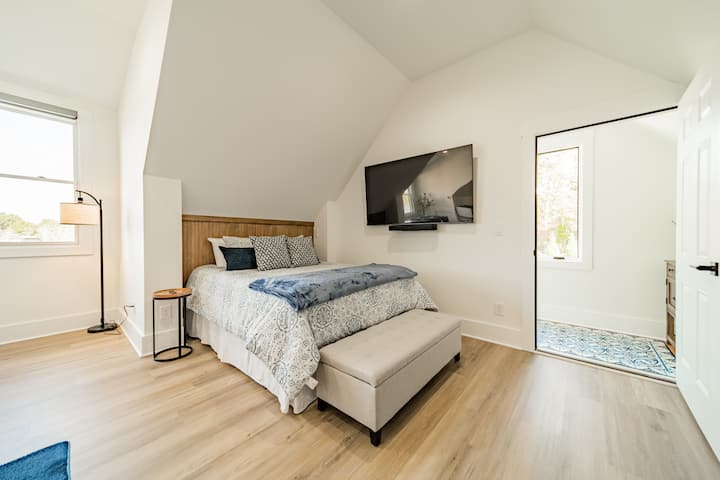 Queen bed and 65" smart television with sound bar.