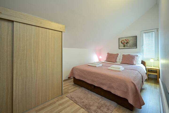 粉色阁楼房间，配有舒适的标准双人床—柔和的色调和安静的魅力。