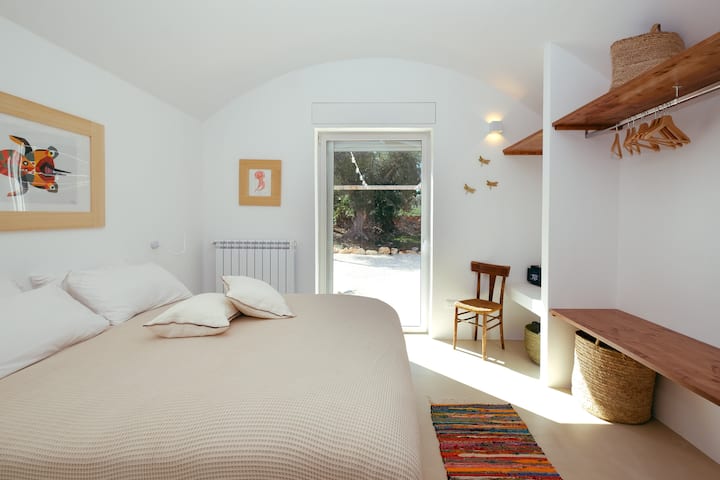 Dormitorio doble en la planta baja con baño privado y acceso directo al jardín.