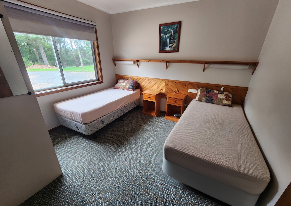 寝室1 - シングルベッド2台（またはリクエストに応じてキングサイズベッド1台）、下部寝具、枕、ベッドサイドテーブル、棚、蛍光灯のベッド照明、遮光カーテン、カーペットフローリング。