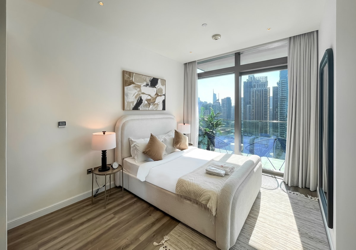 Dormitorio principal luminoso con grandes ventanales y vistas a la ciudad.
