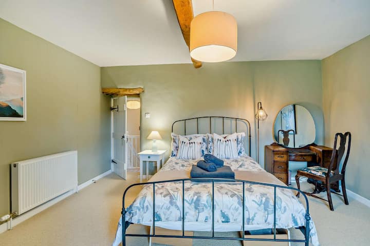 Spacious king room with plenty of storage for clothes, a dressing table and a comfrey chair ideal for reading, feeding your baby, or window gazing over the village green and fields beyond.
