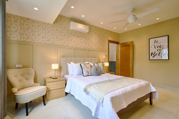 חדר השינה המדהים כולל מיטת קינג מפוארת, מזרן יוקרתי, מזגן, מאוורר תקרה, וילונות שחורים, אורות אווירה, ארון מרווח, טלוויזיה חכמה, שולחן כתיבה, נוף יפה לעיר וחדר רחצה צמוד יוקרתי עם מקלחת גשם.