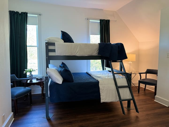 מיטה זוגית מעל מיטת קומתיים מלאה. יש כריות ומצעים נוספים. ארון גדול זמין לאחסון. 