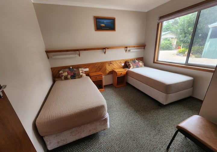 Საძინებელი 1 - ორი ერთადგილიანი საწოლი (ან 1 საწოლი მოთხოვნისამებრ), საწოლისპირა მაგიდები, ზედაპირული ფლუორესცენტული განათება, თაროები. ქვედა თეთრეული, ბალიშები, ხალიჩის იატაკი, უშუქო ფარდა.