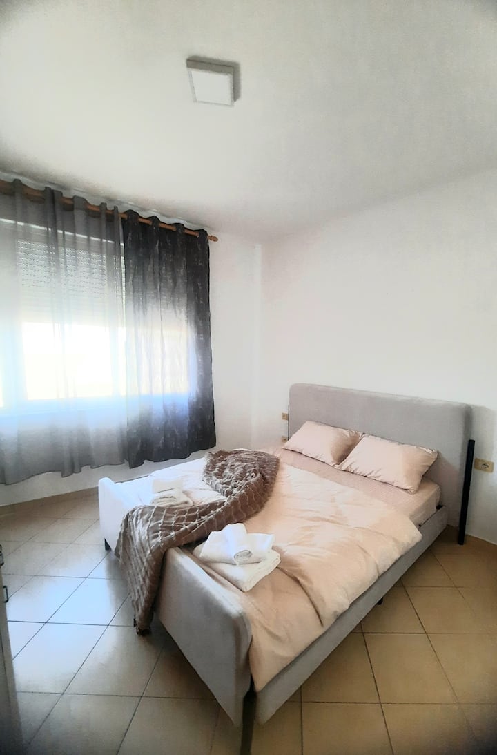 La chambre dispose de grandes fenêtres qui laissent entrer une lumière naturelle abondante, créant une atmosphère chaleureuse et accueillante.