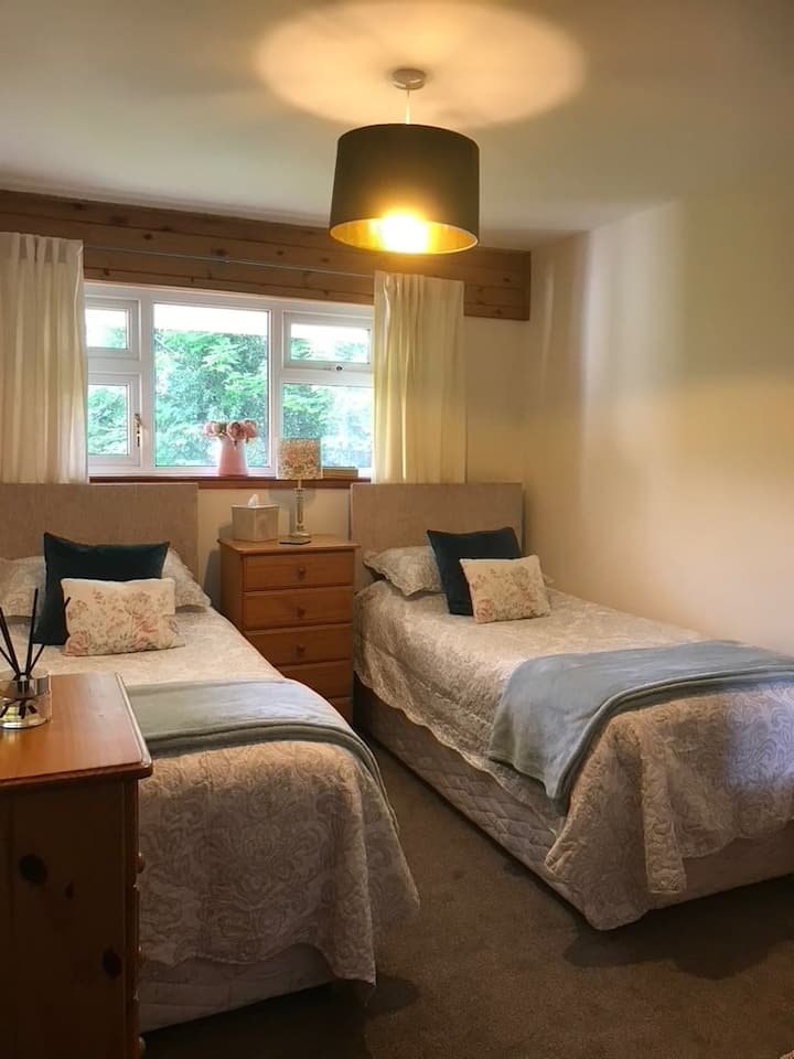 2 single beds with 2 pillows and a duvet each. Bedspread and extra blanket. 
2 small chest of drawers and a wardrobe.
Blanket box with owners things in. Spare blankets in the wardrobe drawers. 