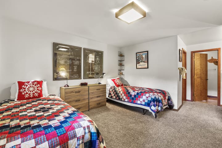 Bright and cozy bedroom with twin beds and colorful quilts.