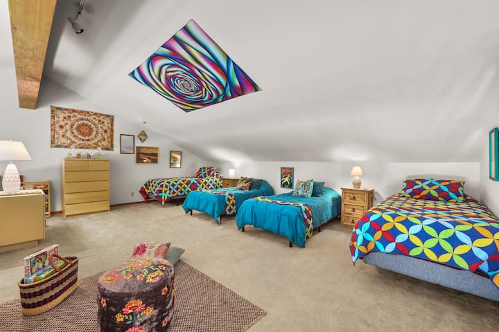 Colorful and spacious living area with vibrant décor and cozy bedding.