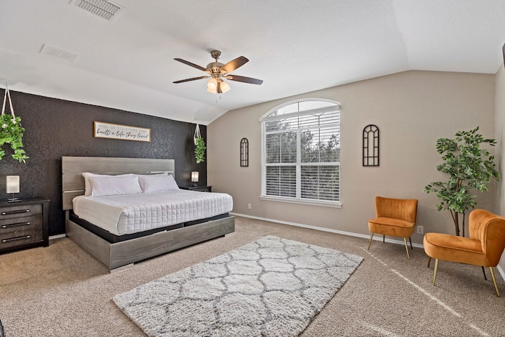 広々とした穏やかな寝室には、豪華なキングサイズベッド、豪華なカーペット、アーチ型の窓から自然光が差し込んでいます。 モダンなインテリア、居心地の良い座席、緑が特徴で、リラックスして快適に過ごすのに最適なリトリートです。