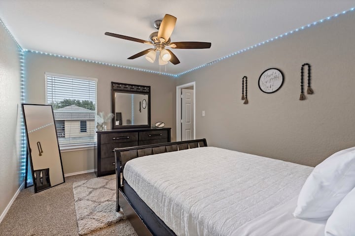 快適なクイーンサイズベッド、柔らかい照明、スタイリッシュなインテリアを備えた魅力的な寝室。 シーリングファン、居心地の良いカーペット、エンスイートクローゼットへの便利なアクセスを備えたこのお部屋は、ゲストに平和でリラックスしたリトリートを提供します。