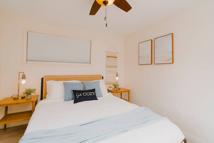 Bright, airy, and inviting. This serene queen bedroom features modern decor and a ceiling fan for personalized comfort on those mild PNW nights.