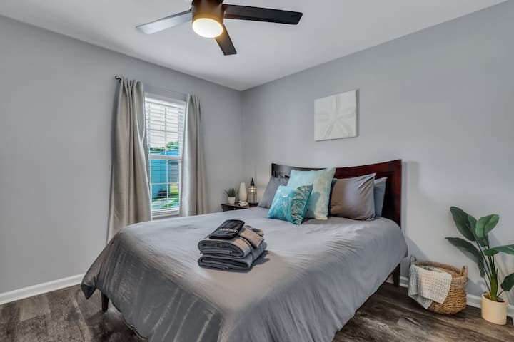 Camera da letto luminosa con letto a due piazze, dettagli in stile costiero color verde acqua e ventilatore a soffitto — rilassante rifugio ispirato alla Lowcountry a North Charleston, SC
