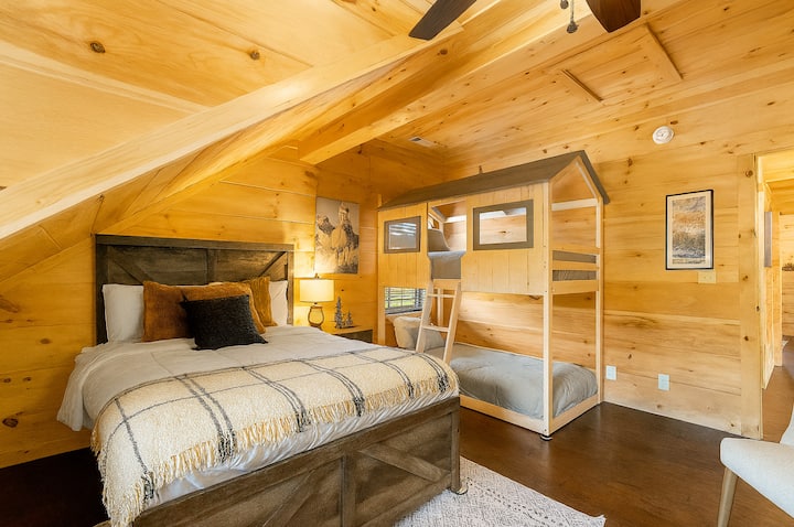 Სრული ზომის საწოლი და უსაყვარლესი საბავშვო ორსართულიანი საწოლები ტელევიზორით. საძინებელი მდებარეობს ზემოთ