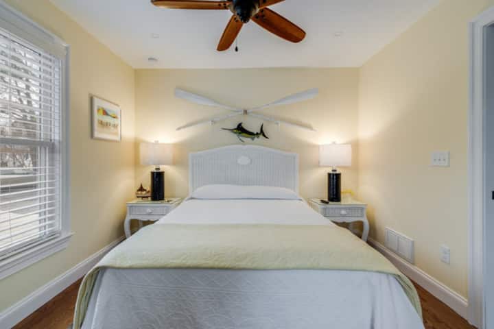 快適なクイーンベッドを備えた明るく楽しい寝室は、メインのリビングエリアから離れた1階にあり、静かな休憩場所を提供しています。  