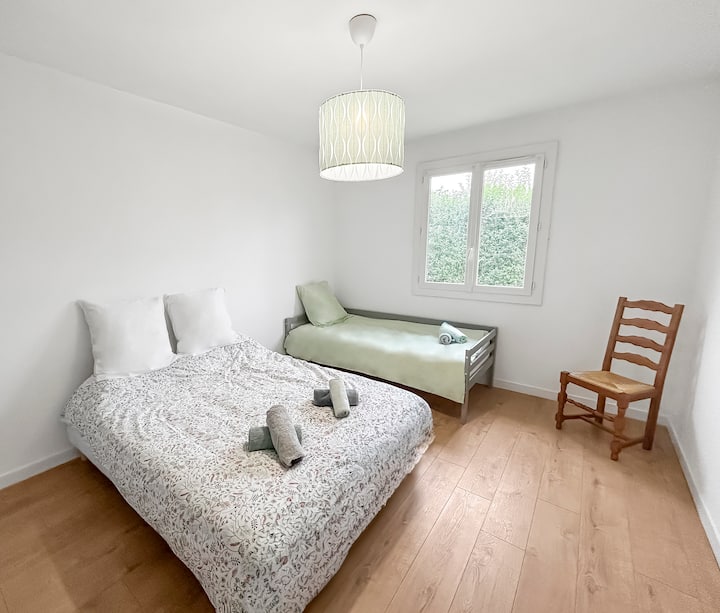 Amplia habitación equipada con cama de matrimonio y cama individual, ideal para familias o grupos de amigos. Vistas al jardín.