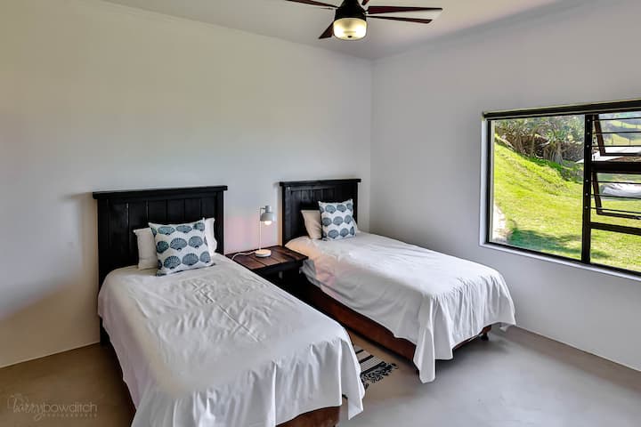 سريران منفردان داخل كوخ لاغون إيدج بغرفتي نوم بجوار رمال الشاطئ مباشرة. حمام مشترك.