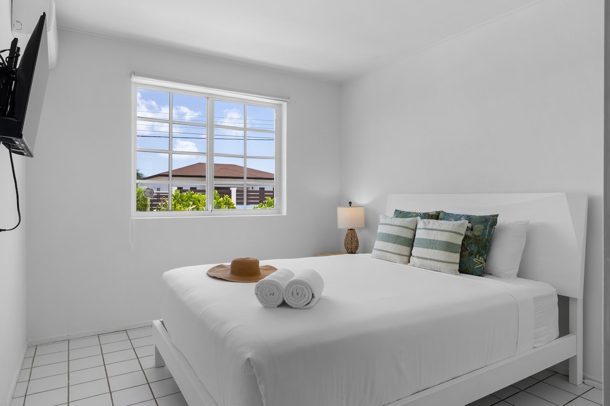 Განიტვირთეთ დედოფლის ამ ნათელ საძინებელში რბილი ბალიშებით, გრილი კონდიციონერითა და მზიანი ბაღის ხედით.